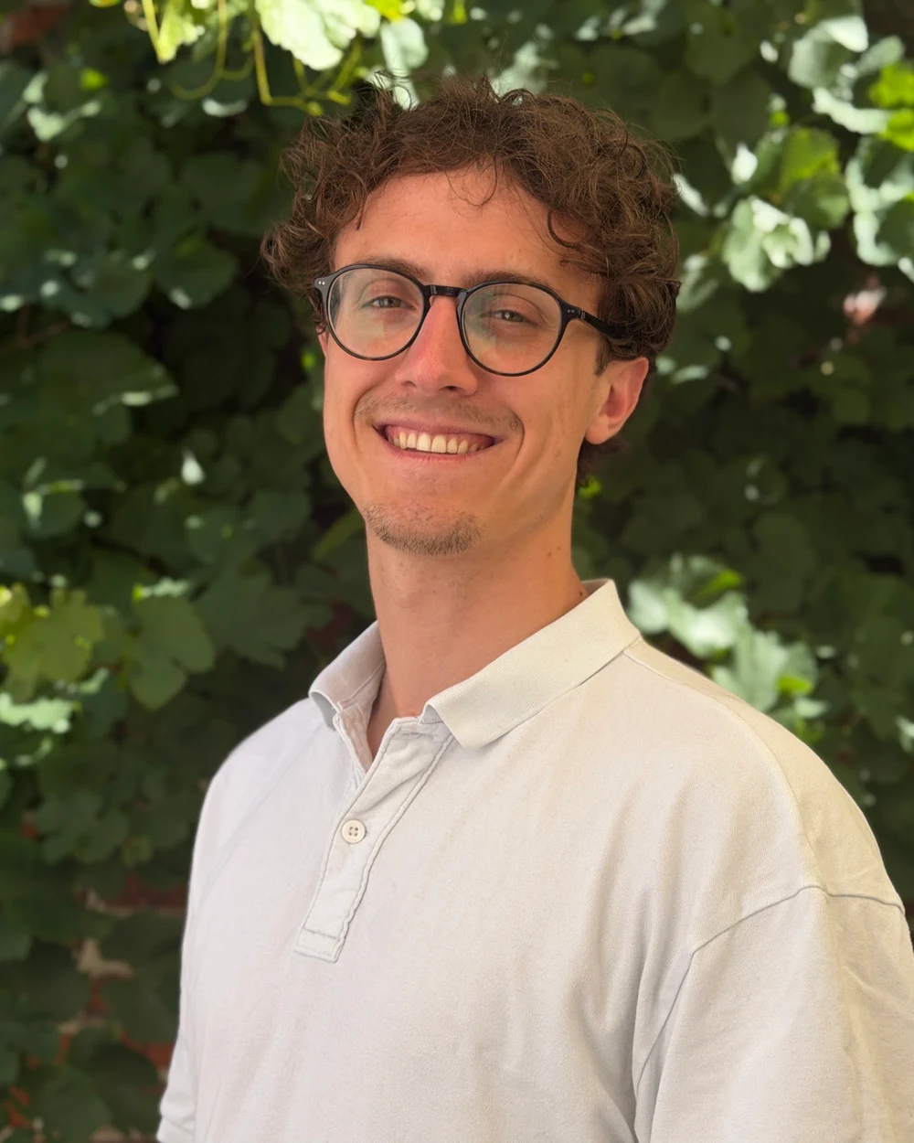 Sebastian Riehm vor der begrünten Backsteinwand im Hof